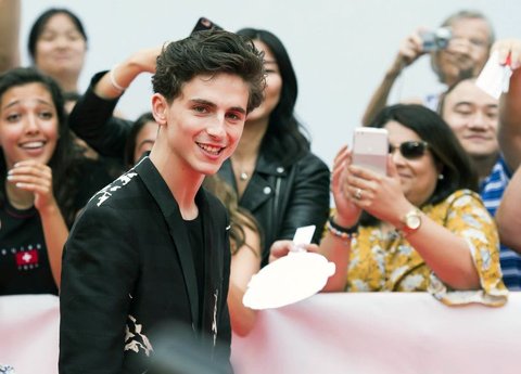 Actor Timothee Chalamet poses for photographs on the red carpet after arriving for the new movie 