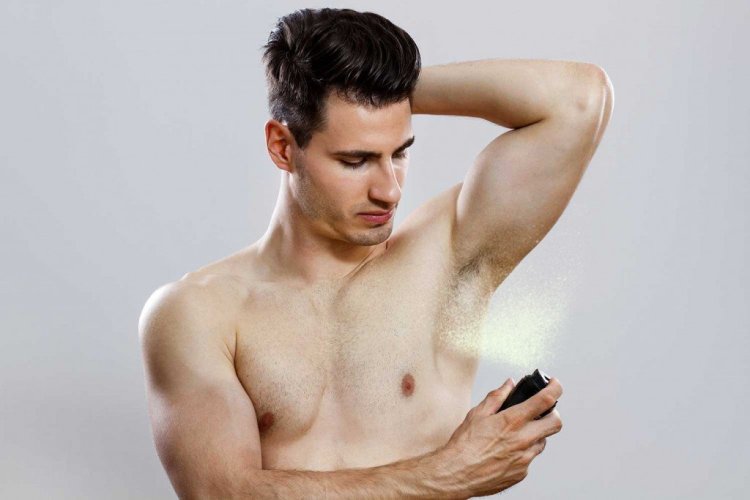 Handsome Man Spraying Deodrant Inesbazdars