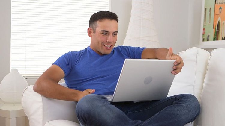 Cheering Hispanic Man Watching Sports On Laptop Co