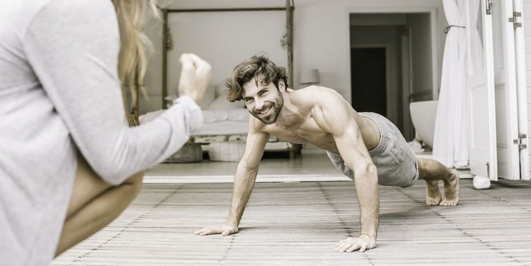 Young Man With Girlfriend Doing Press Ups High Res